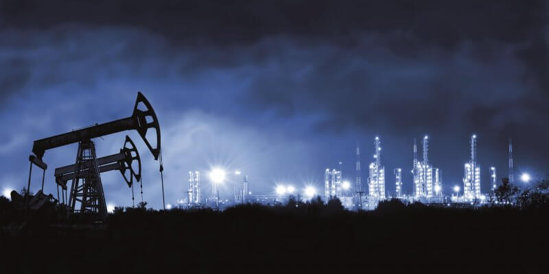 Pump jack and grangemouth refinery at night.